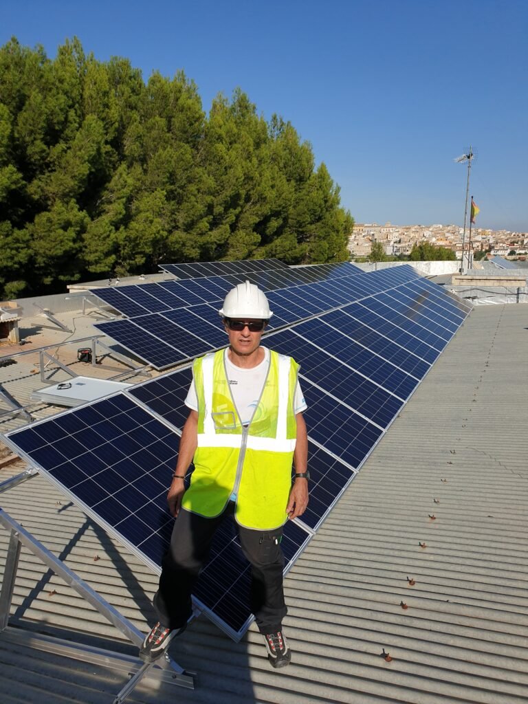 Ingeniero con caso y chaleco encima de un tejado de una instalación solar de autoconsumo