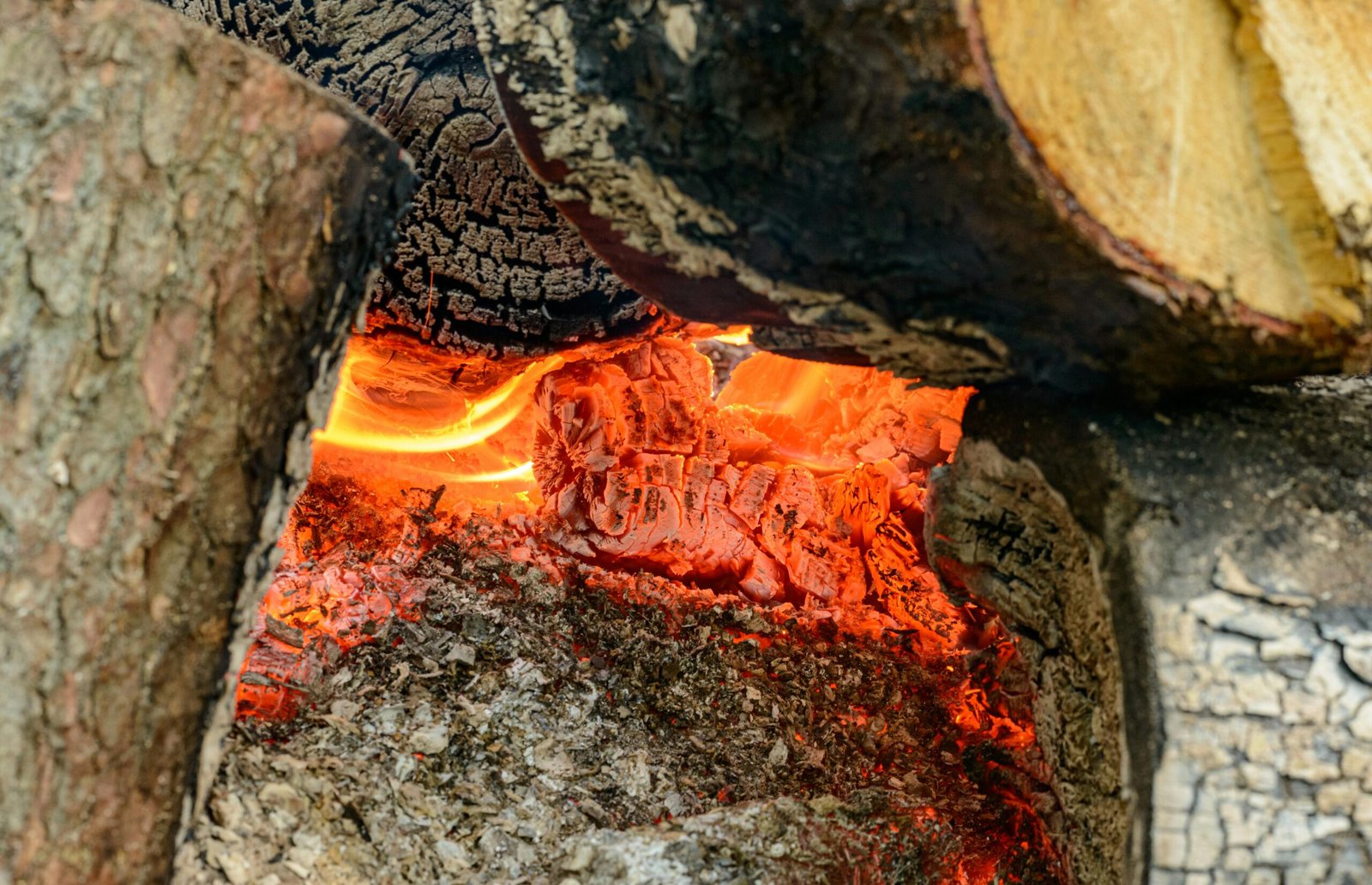 A detailed shot of glowing embers and burning wood showing intense heat.